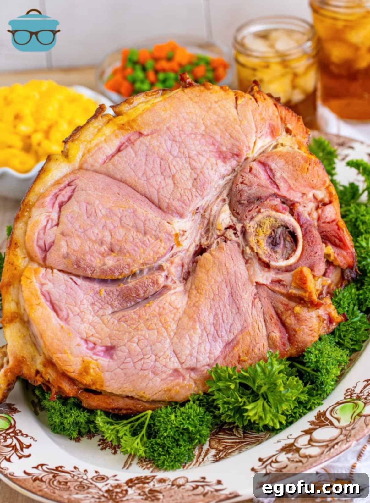 Mahogany Glazed Ham 14 A platter of beautifully sliced Brown Sugar Glazed Ham, garnished with fresh parsley, ready to be served at a holiday meal.