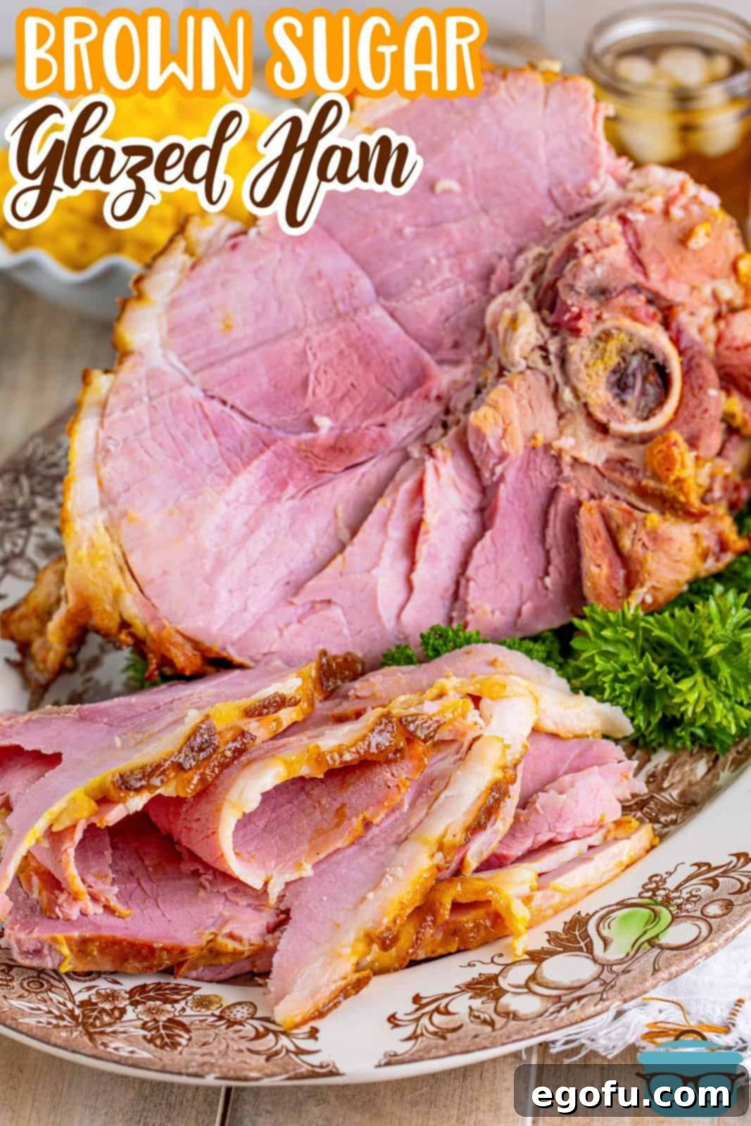 Mahogany Glazed Ham 3 Beautifully carved Brown Sugar Glazed Ham presented on a plate, with the larger ham on a platter in the background, perfect for a Pinterest share.
