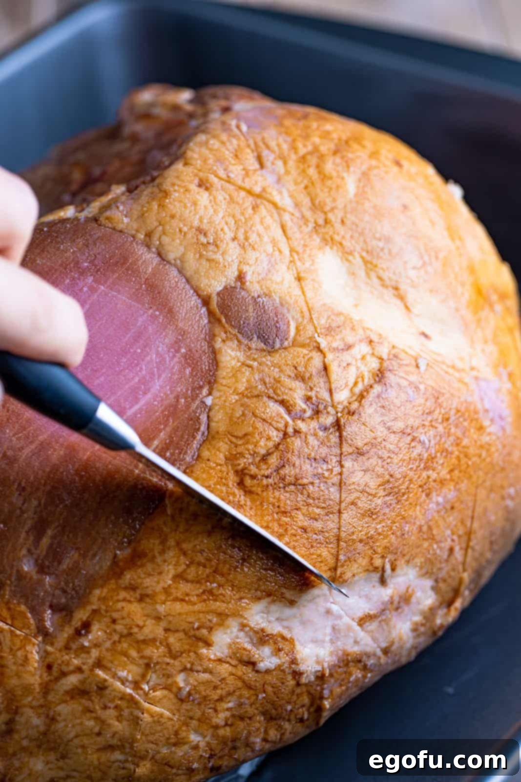 Mahogany Glazed Ham 7 A chef's knife scoring the surface of the ham in a neat diamond pattern.