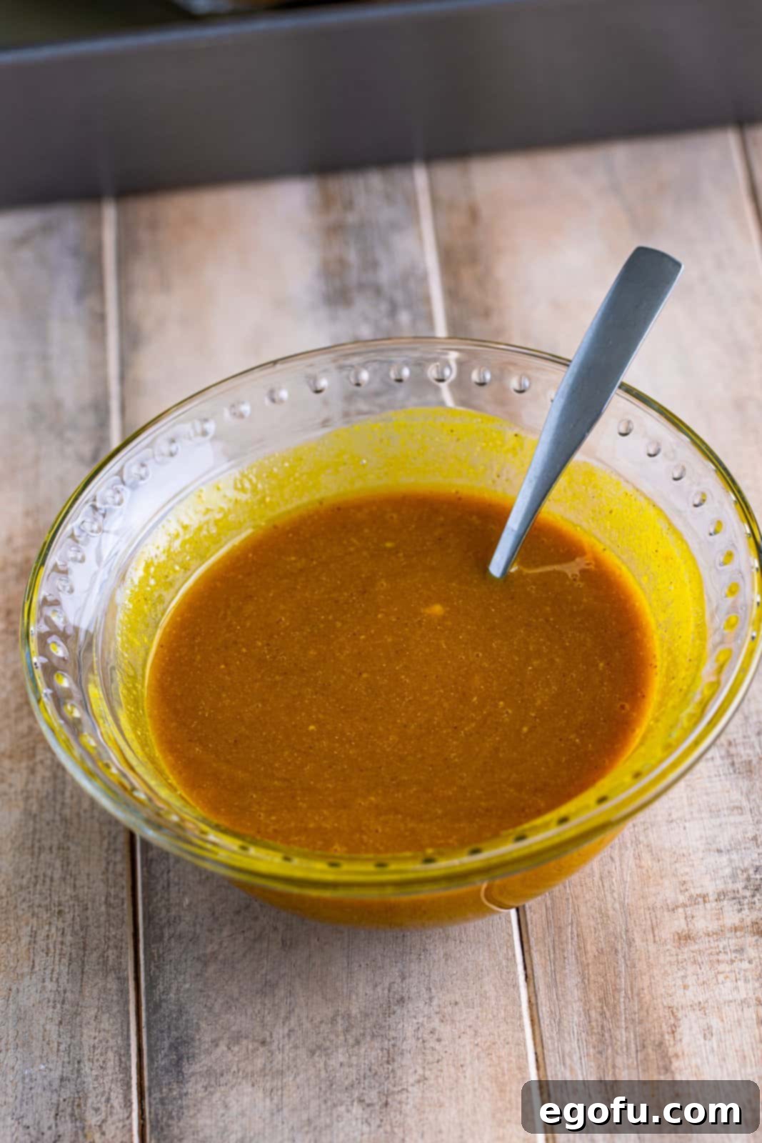 Mahogany Glazed Ham 9 A bowl containing pineapple juice, brown sugar, yellow mustard, garlic powder, onion powder, and ground cloves, mixed into a smooth glaze.