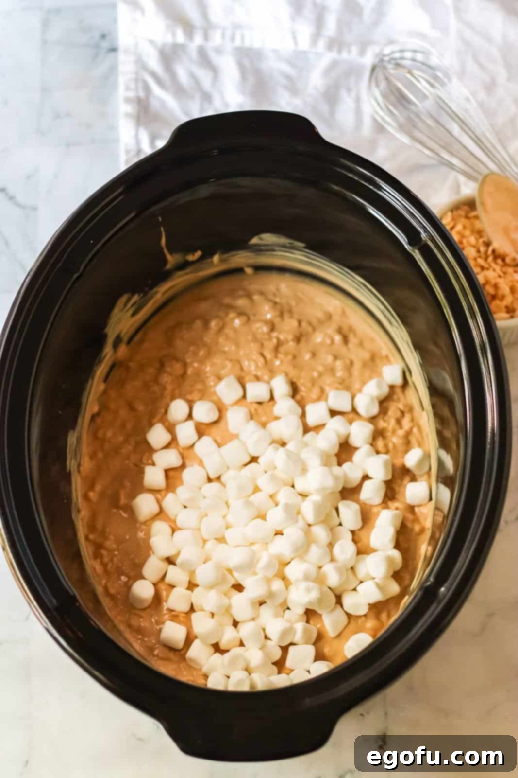 Mini marshmallows added to almond bark, peanut butter, and Rice Krispies mixture, ready for final stir.