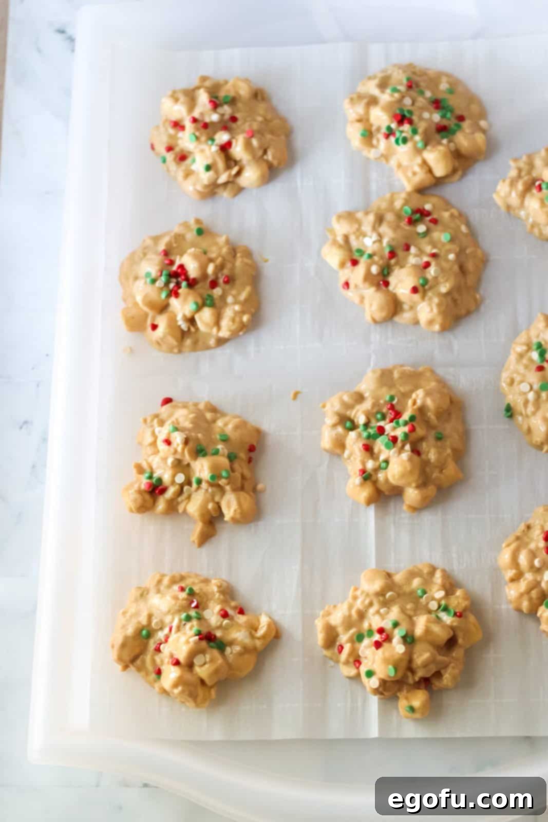 Shaped Crock Pot Avalanche Cookies on parchment paper, freshly topped with sprinkles.
