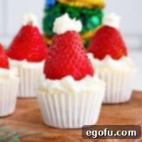 Jolly Santa Hat Cheesecakes 15 Close up square image of Santa Hat Mini Cheesecakes on wooden board garnished.