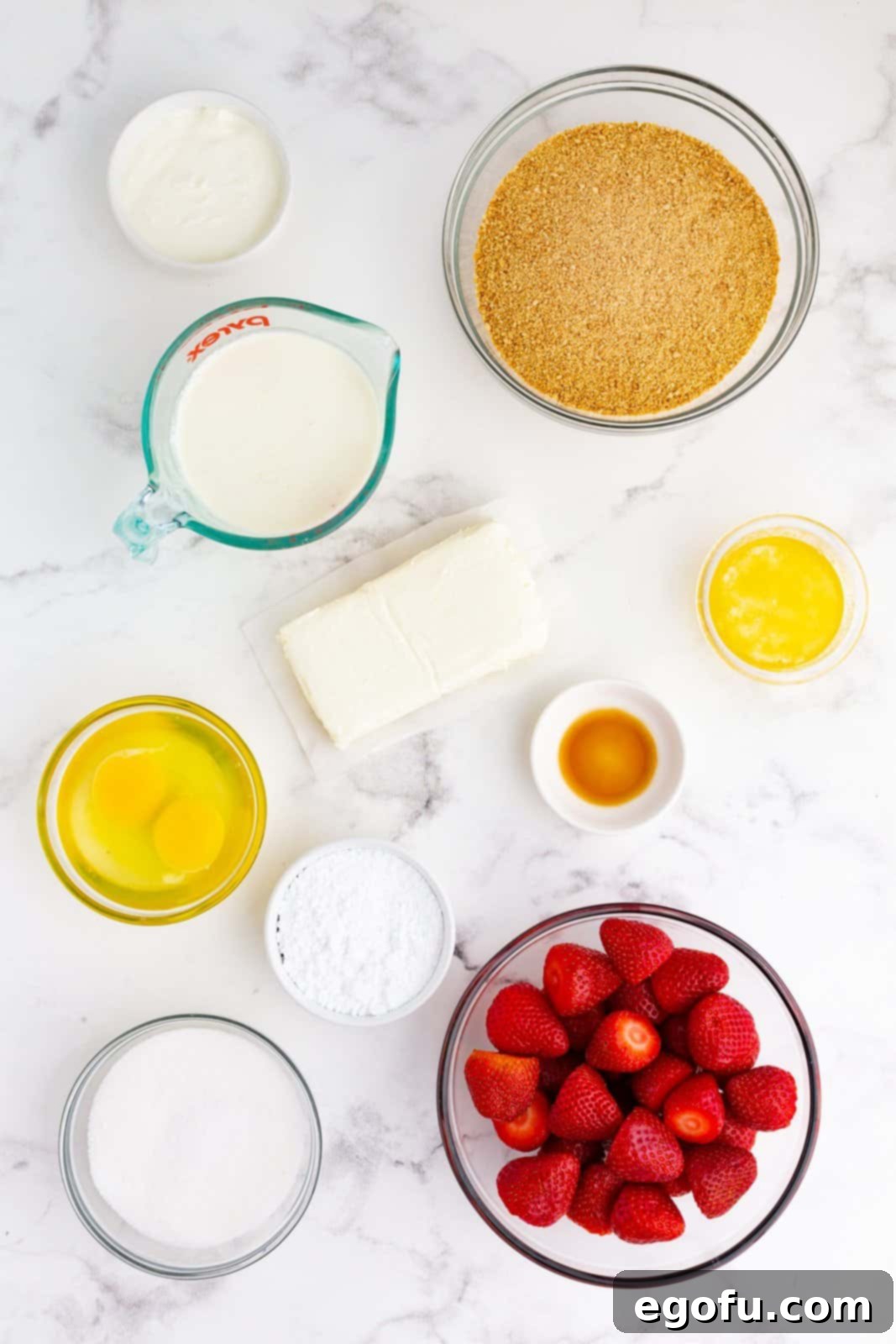 Jolly Santa Hat Cheesecakes 4 Ingredients needed: graham cracker crumbs, salted butter, cream cheese, granulated sugar, eggs, sour cream, vanilla extract, heavy whipping cream, powdered sugar and strawberries.