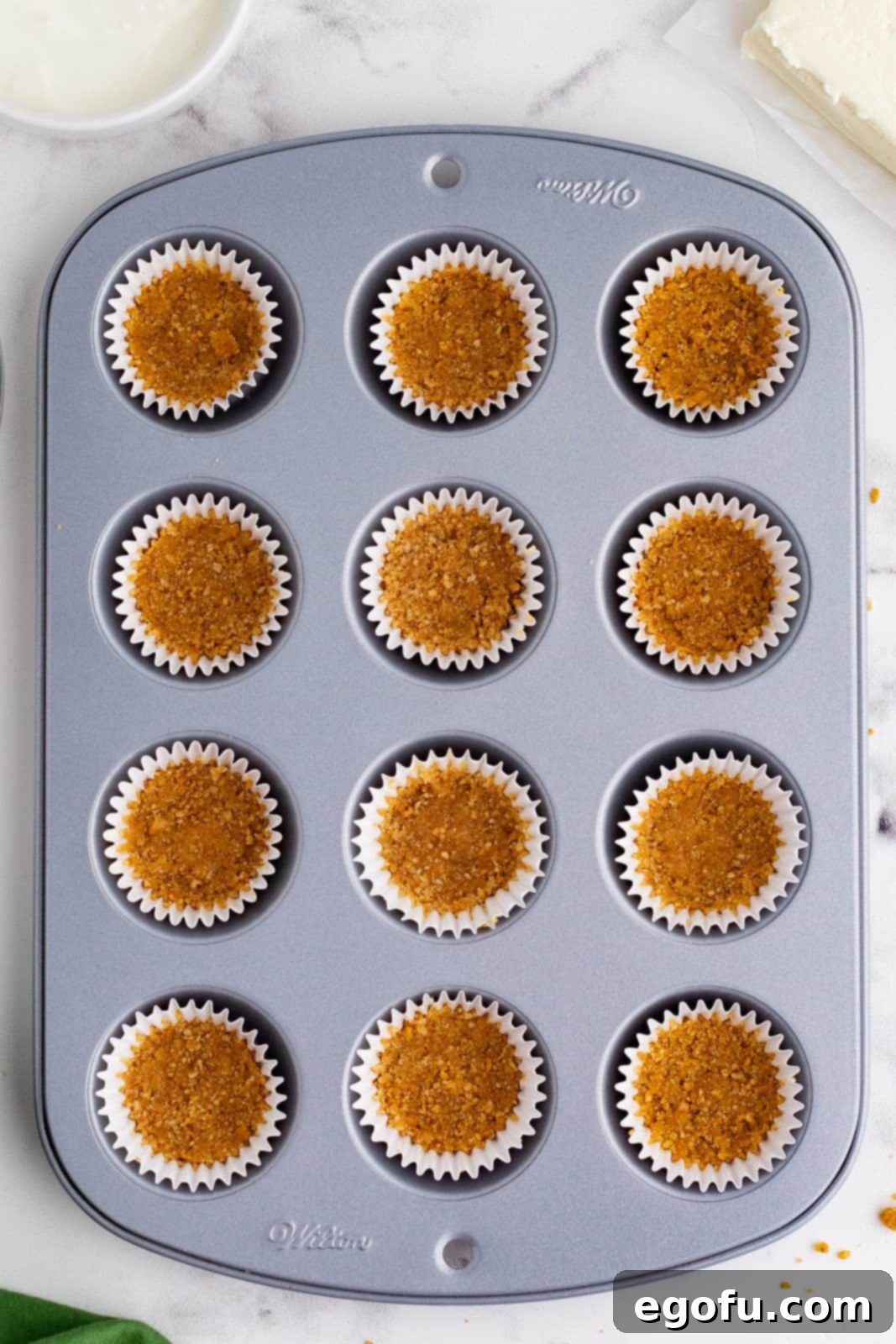 Jolly Santa Hat Cheesecakes 6 Crust pressed into mini liners in mini cupcake pan.