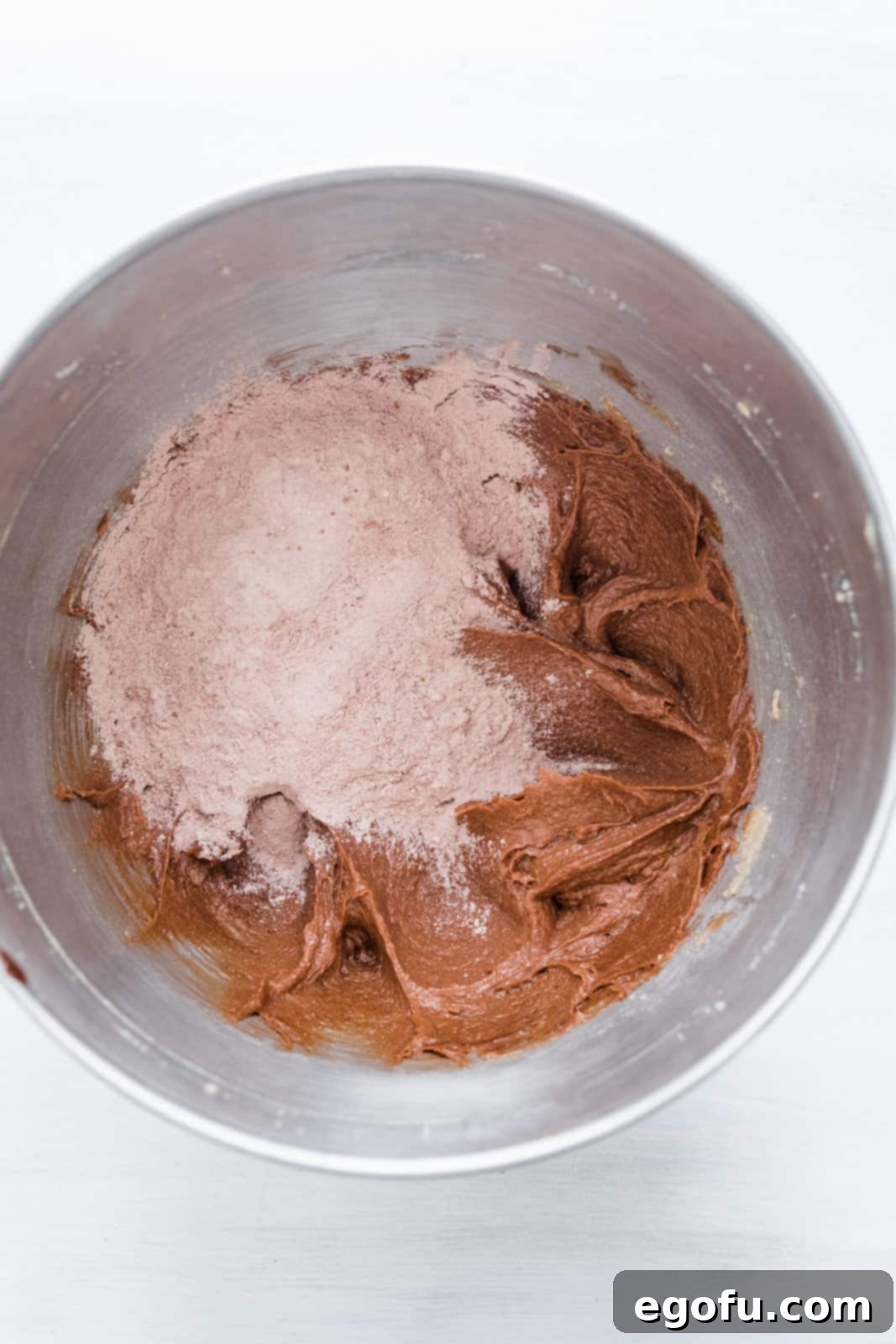 Flour and cocoa powder mixture added to bowl of stand mixer.