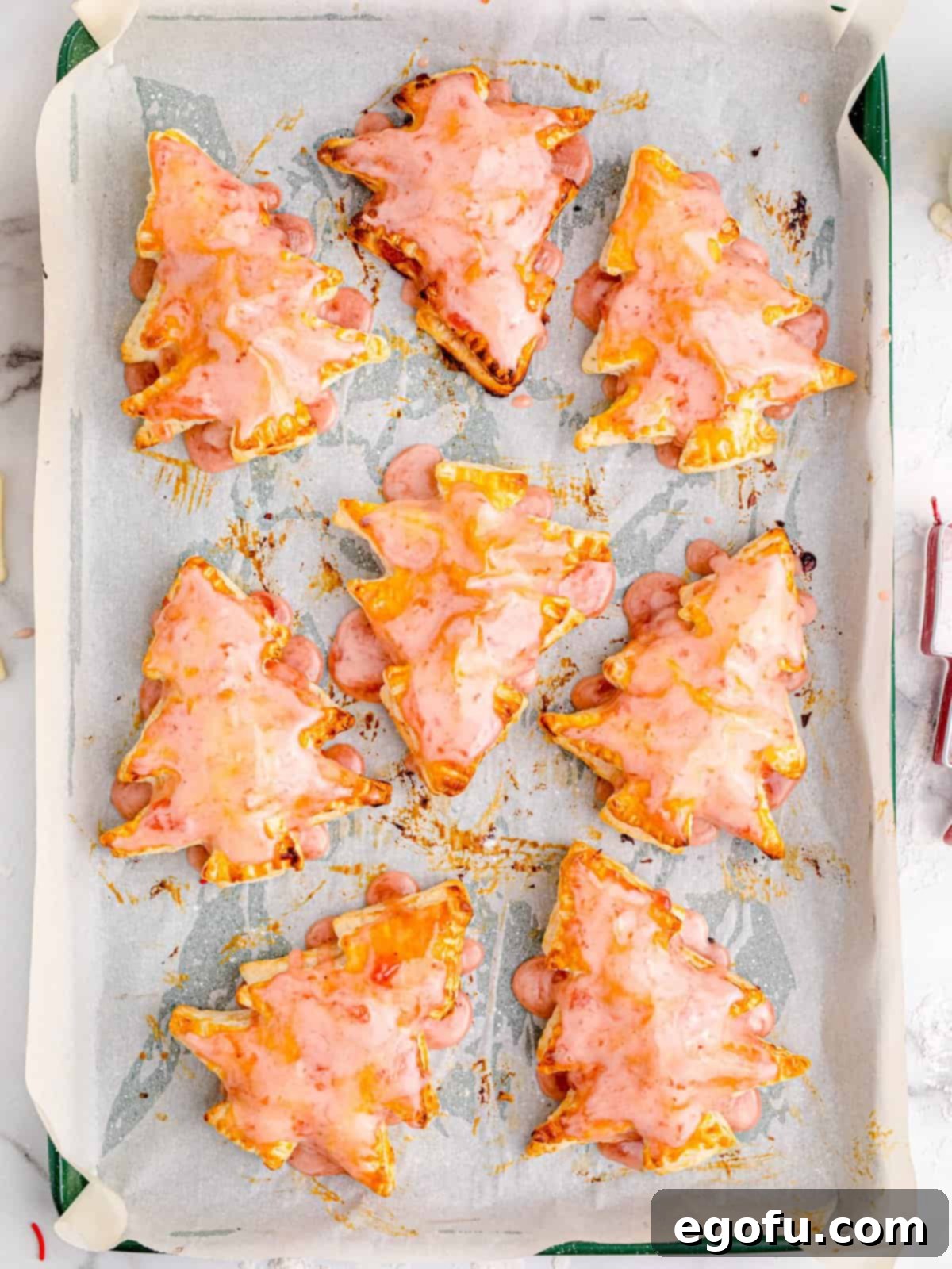 Sparkling Spruce Pop Tarts 10 Icing being spread over the tops of the baked Christmas Tree Pop Tarts, ready for sprinkles.