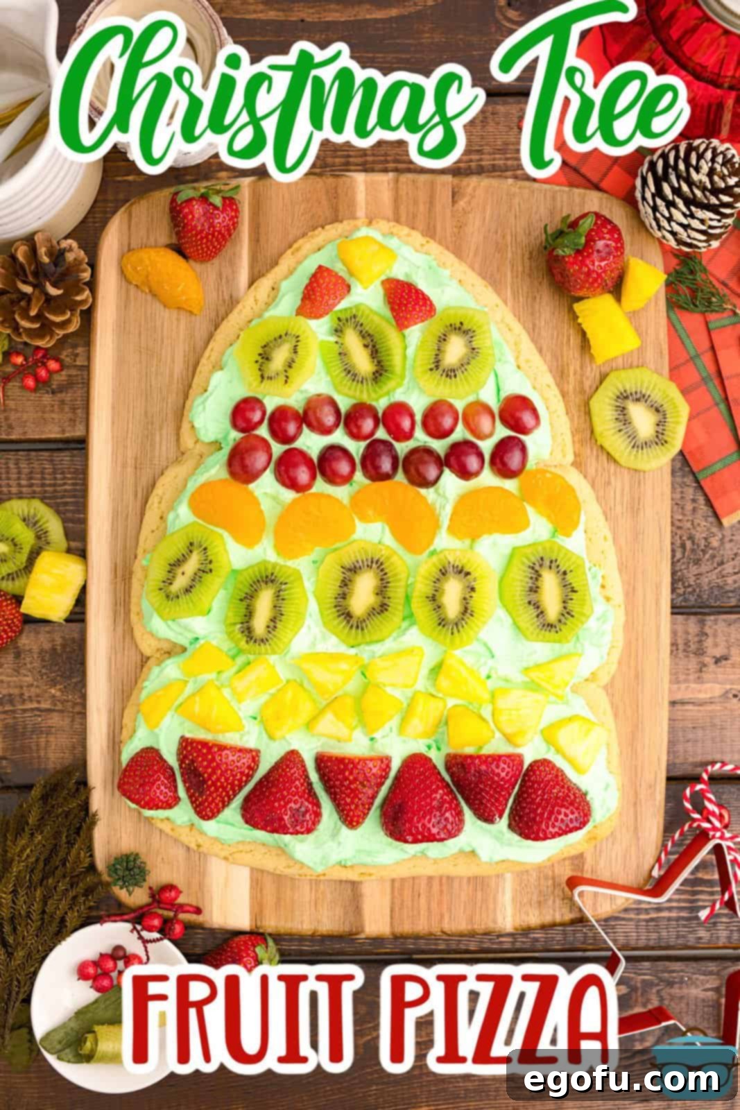 Close-up of a beautifully decorated Christmas Tree Fruit Pizza ready for serving, showcasing the vibrant fruits and green topping.