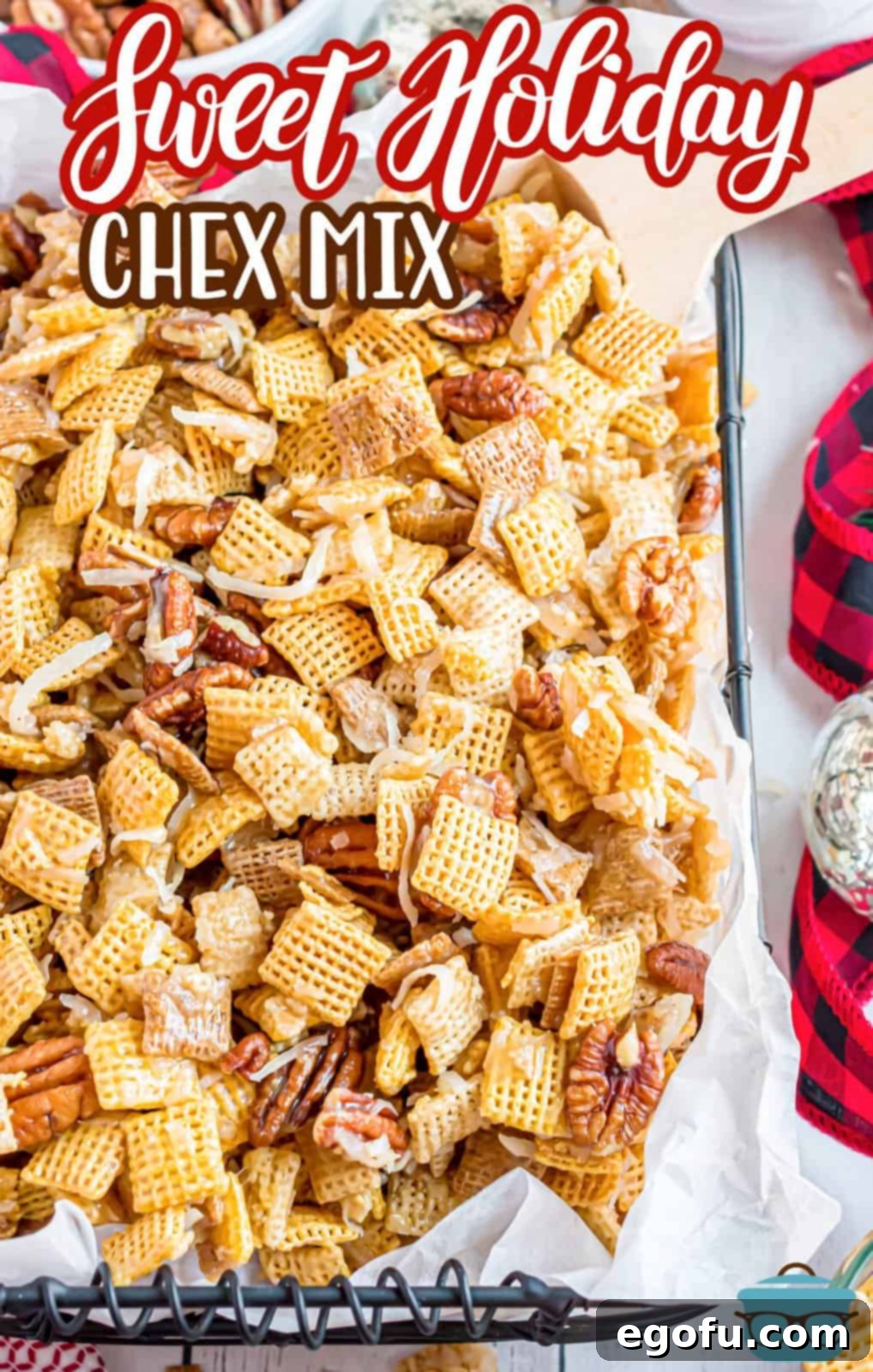 A close-up of Sweet Holiday Chex Mix spread on parchment paper, highlighting its sweet glaze and varied textures.