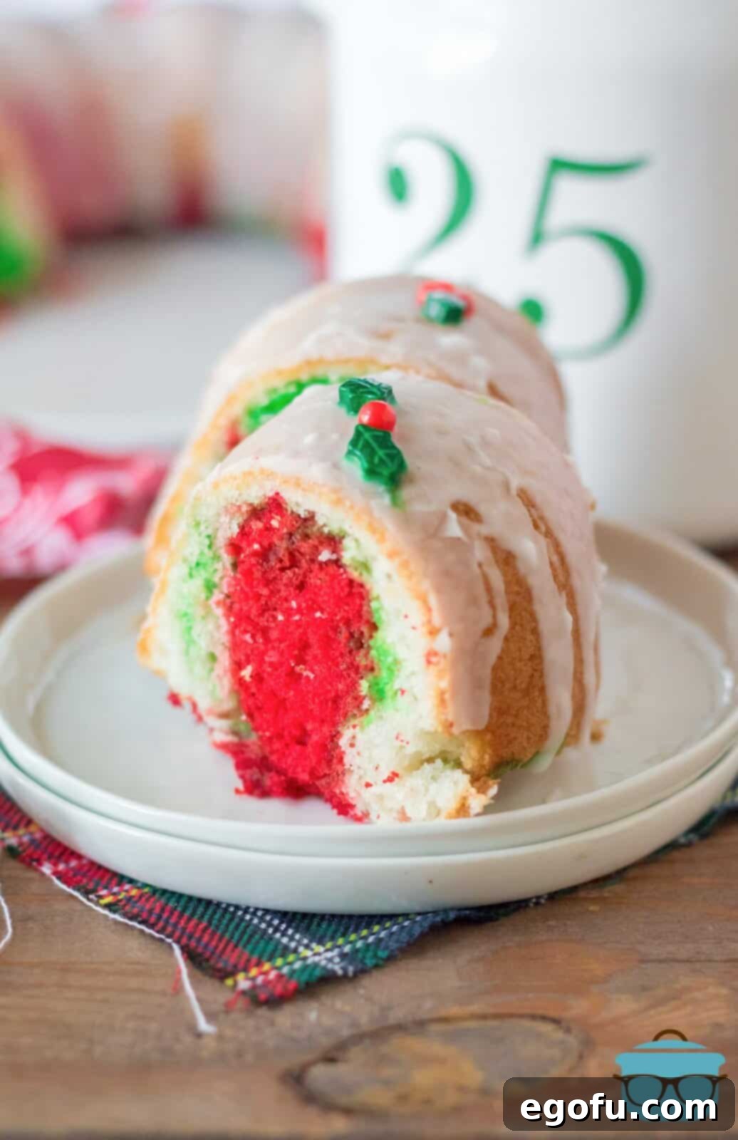 two slices of Christmas bundt cake shown on a white plate so you can see the colorful  red and green inside of the cake.