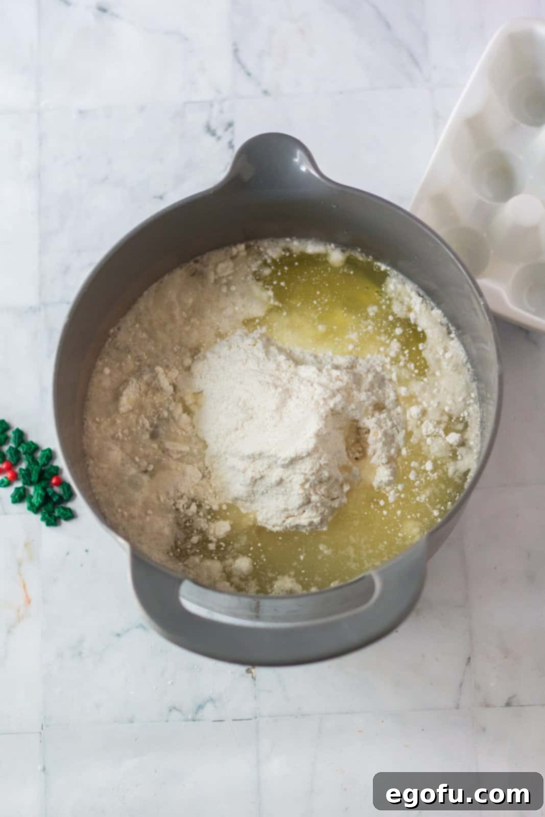 white cake batter withal, egg, whites, water and almond extract in a bowl.