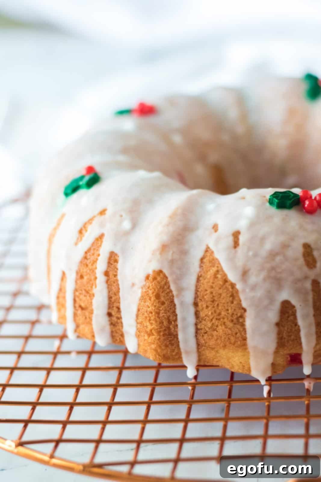 icing shown drizzled over baked bundt cake with holiday sprinkles on top.