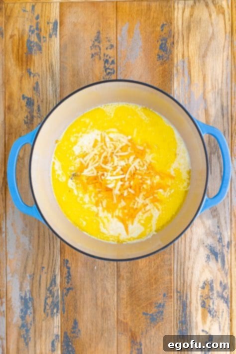 A pot of melted butter, garlic, shredded cheese, cream, and salt and pepper.