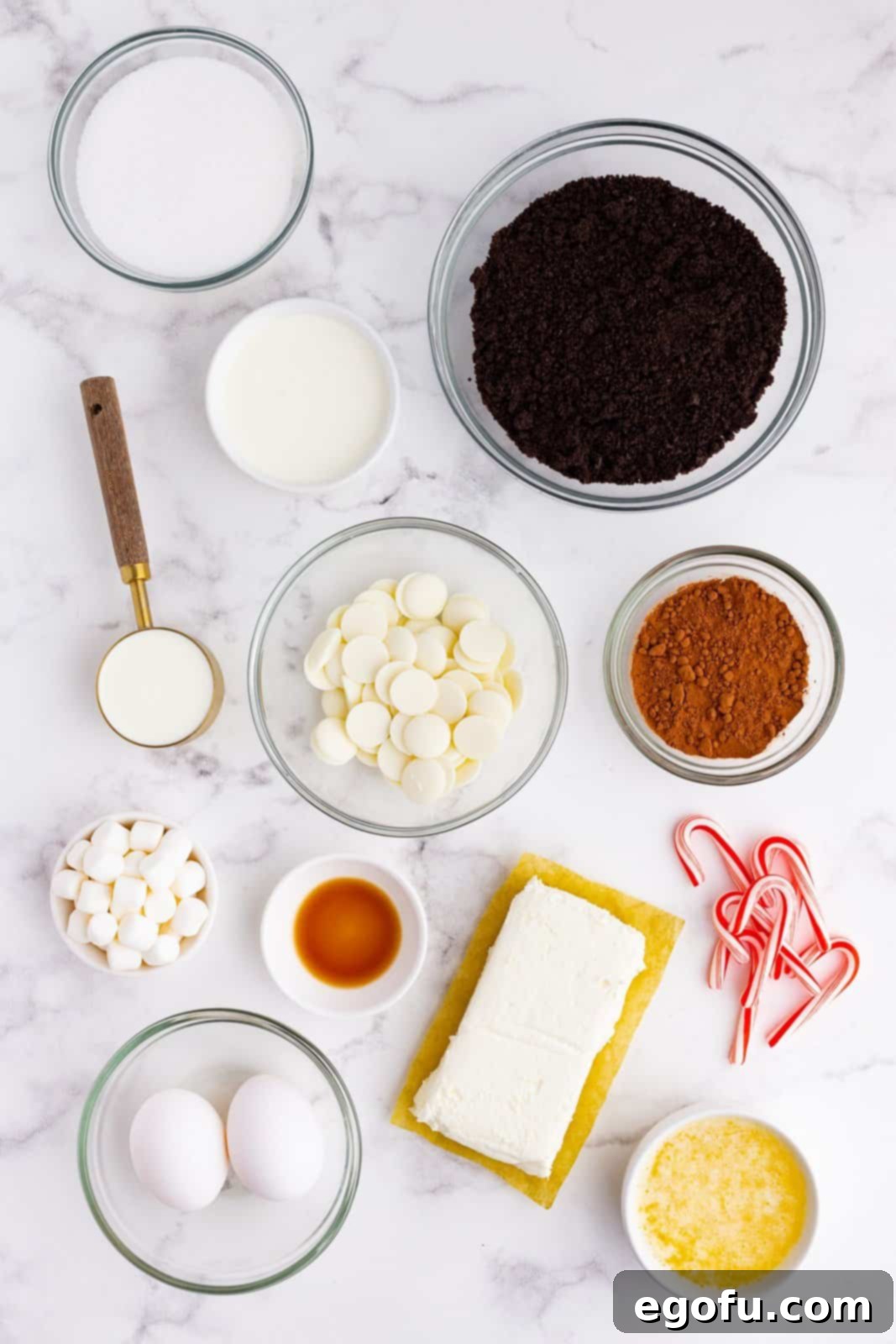 Oreo cookie crumbs, white chocolate, cocoa powder, cream cheese, sour cream, sugar, mini marshmallows, mini candy canes, butter.