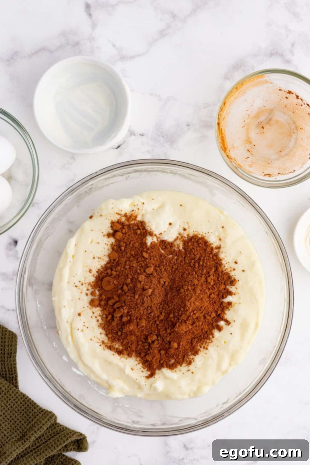 cocoa powder added to cream cheese mixture in a bowl.
