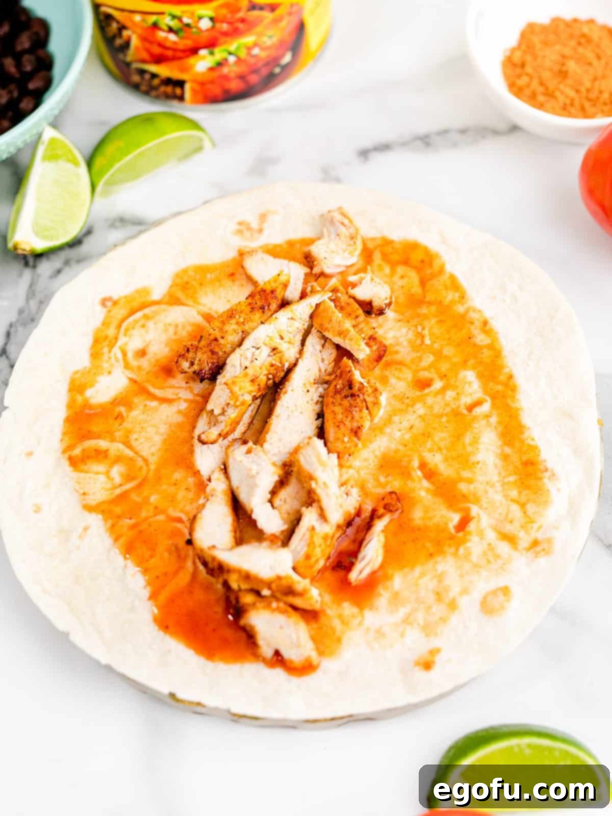 sliced chicken placed in the center of the flour tortilla.