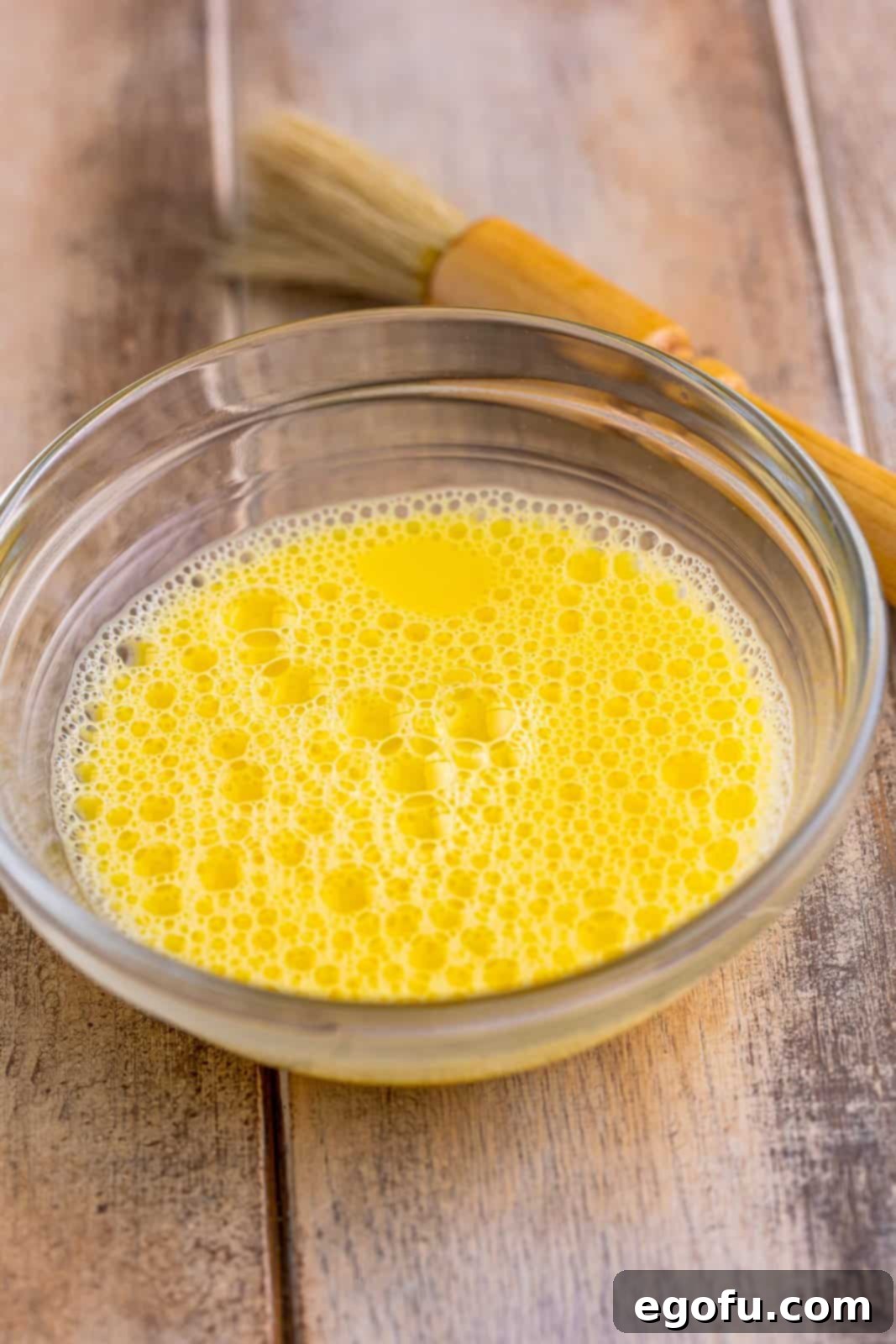 Effortless Ham and Cheese Stromboli Delight 11 egg and water mixed together in a small clear bowl.