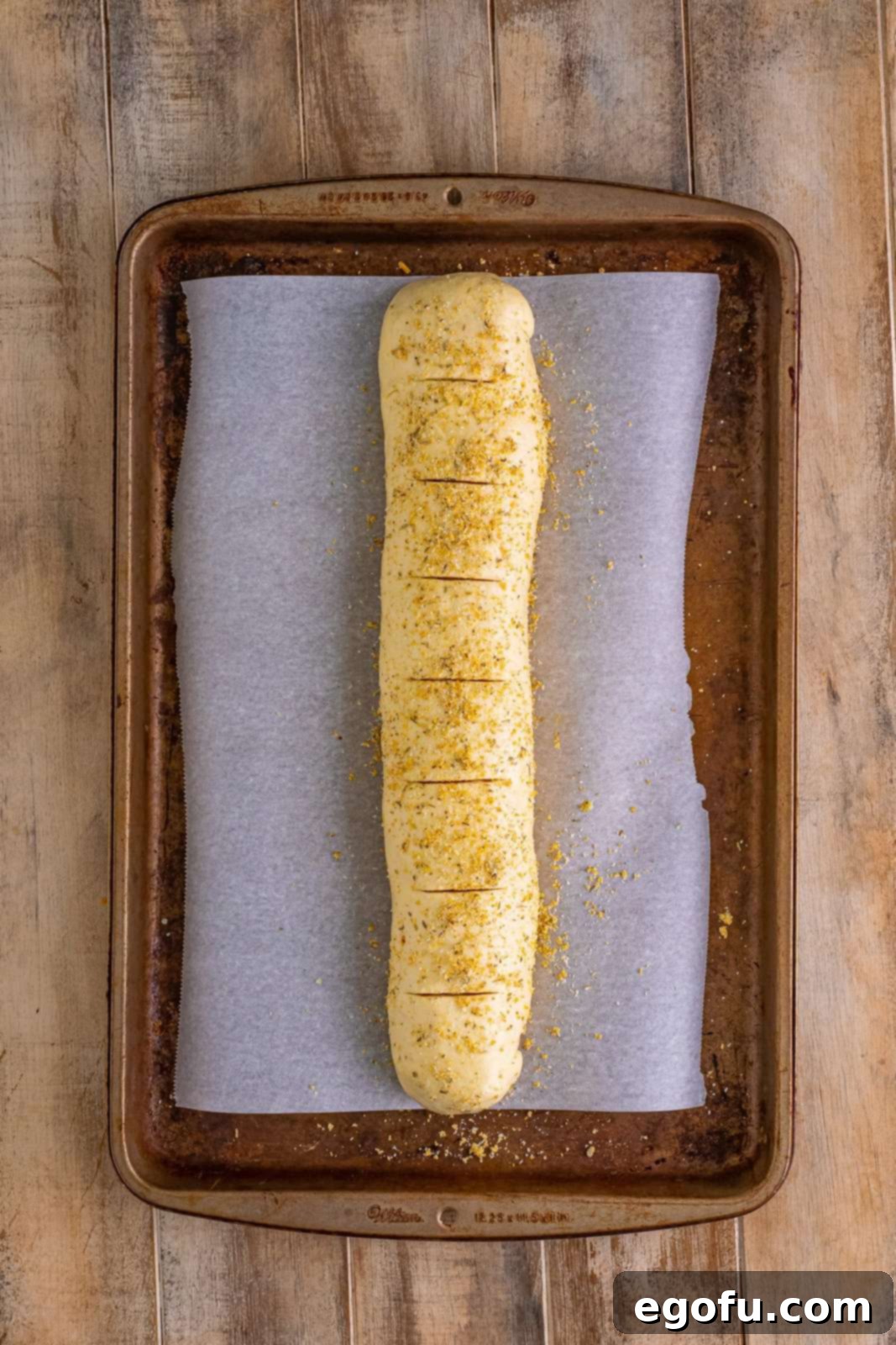 Effortless Ham and Cheese Stromboli Delight 16 slits cut into top of pizza dough.