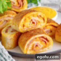 Effortless Ham and Cheese Stromboli Delight 20 slices of ham and cheese Stromboli on a white plate.