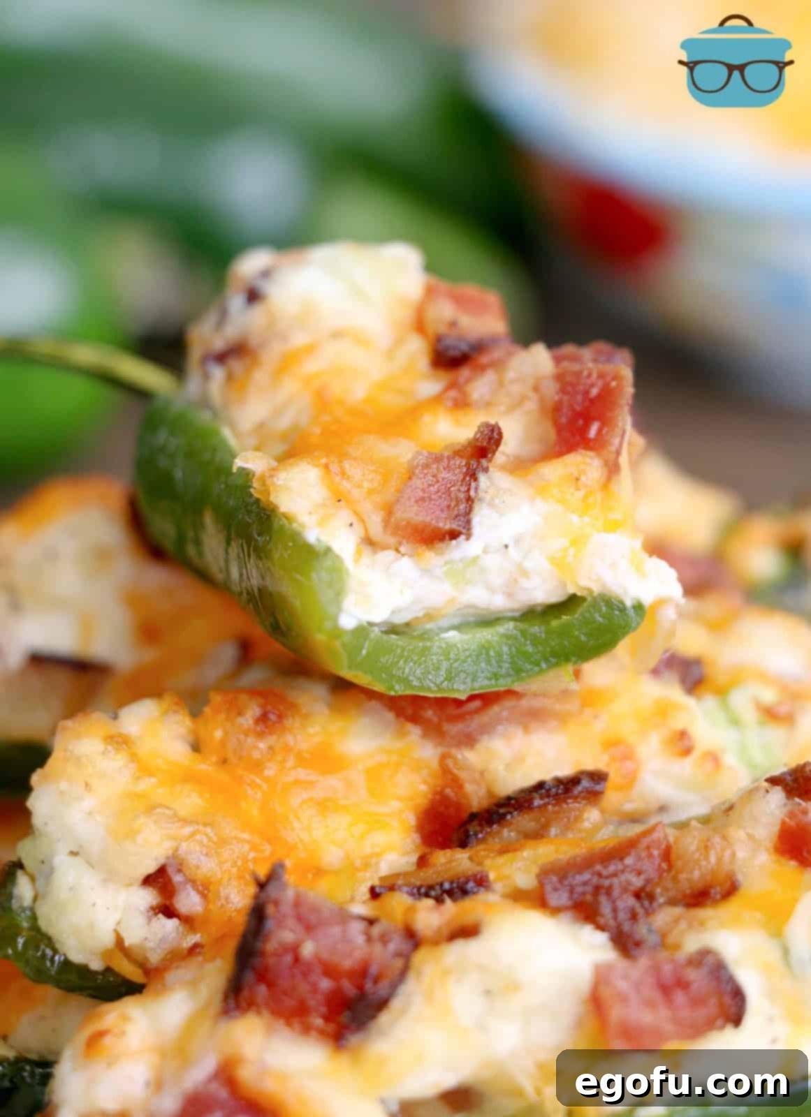 closeup photo of a jalapeño popper with a bite taken out of it. 