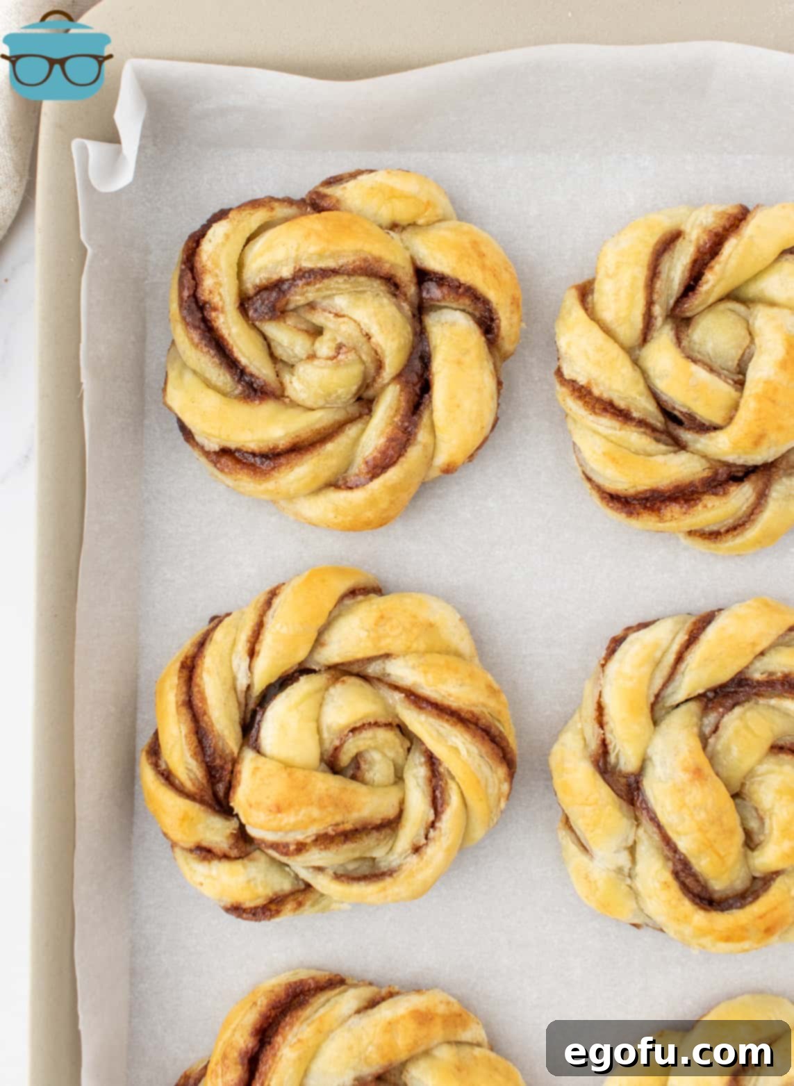 fully baked cinnamon knots shown on a baking sheet. 