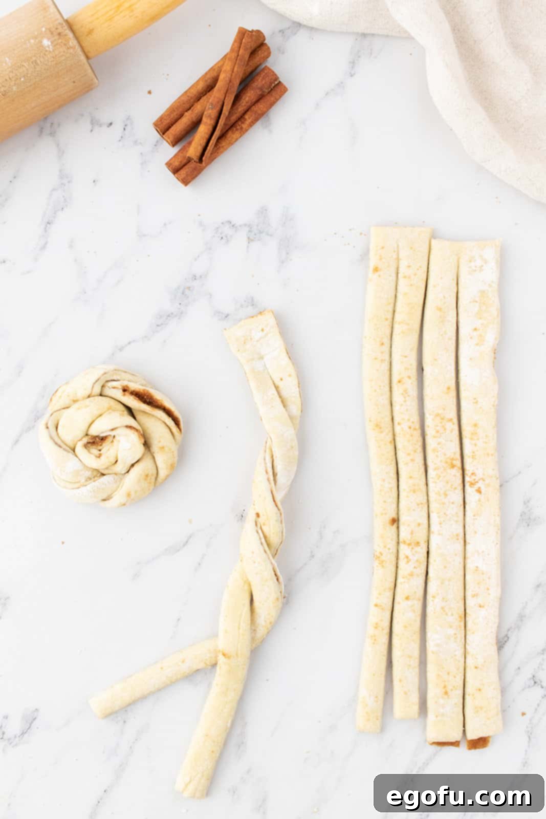 showing two puff pastry strips being twirled around each other.