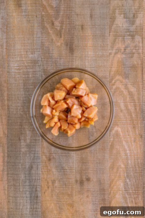 cut up chicken breasts in a glass bowl.