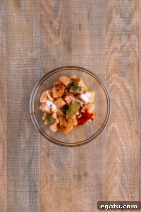 seasonings added to chicken in a bowl