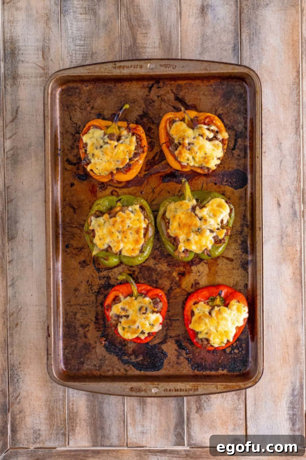 Philly Cheesesteak Pepper Boats 14 fully baked Philly cheesesteak stuffed peppers shown on a cookie sheet.