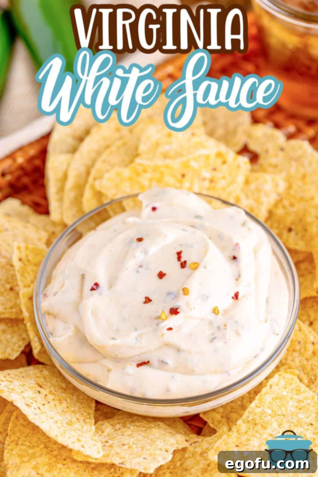 An overhead shot showcasing a small glass bowl of Virginia White Sauce surrounded by perfectly golden yellow corn tortilla chips, ready for serving.