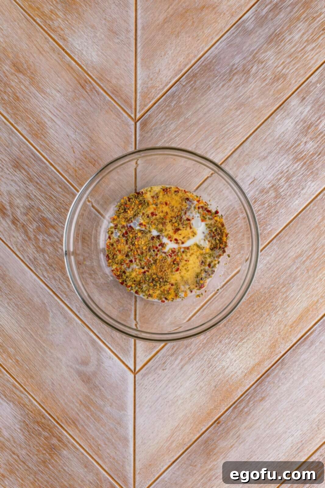 Milk being poured into the bowl containing the spices, ready for whisking.