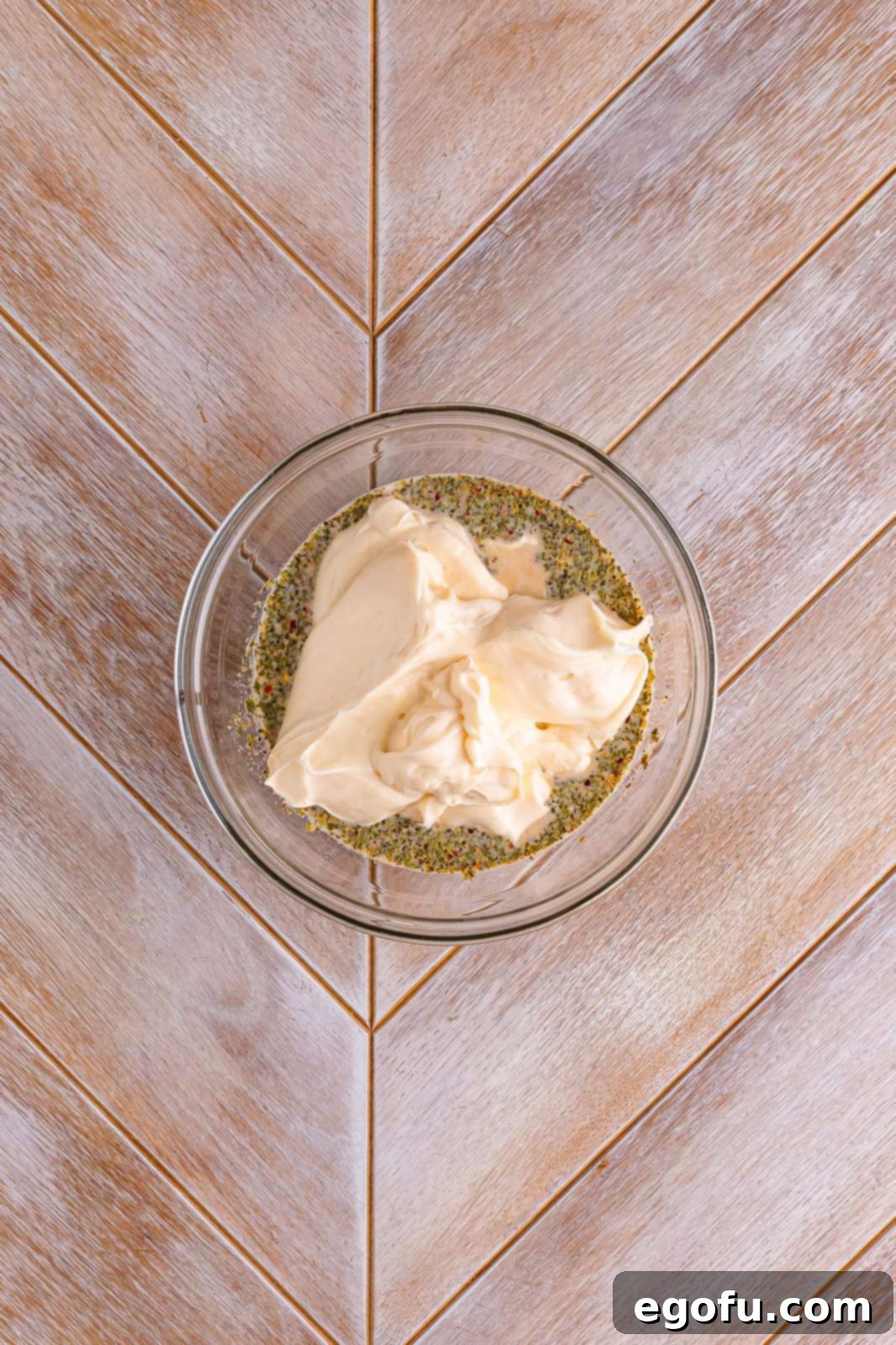 Miracle Whip is added to the milk and spice mixture in a bowl, the final ingredient before blending.