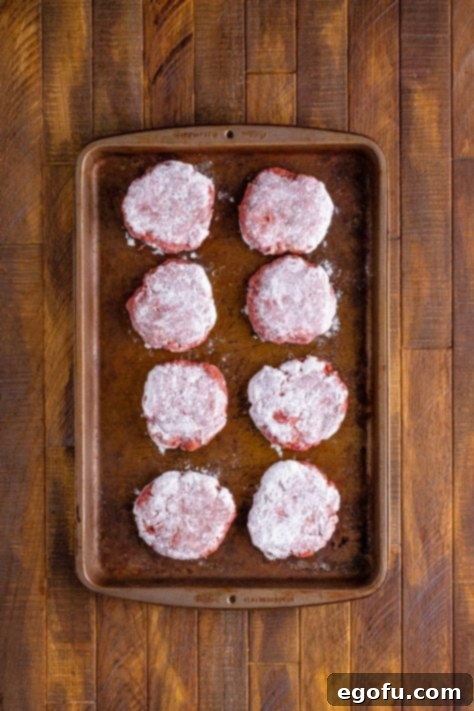 patties after they have been covered in flour and placed back on the baking sheet.