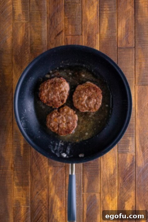 browned hamburger patties shown in a skillet.