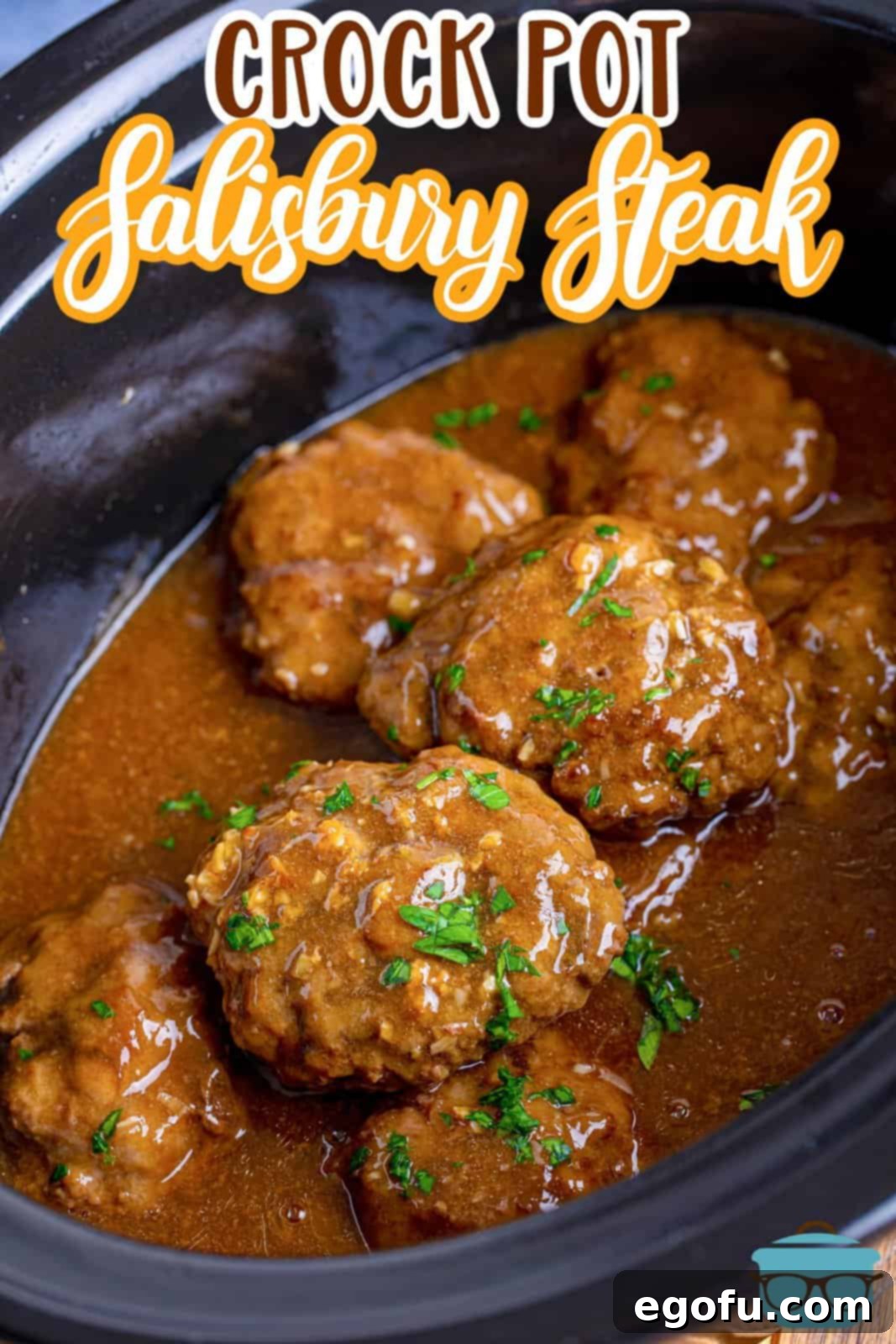fully cooked salisbury steaks with gravy shown in a black, oval slow cooker. 