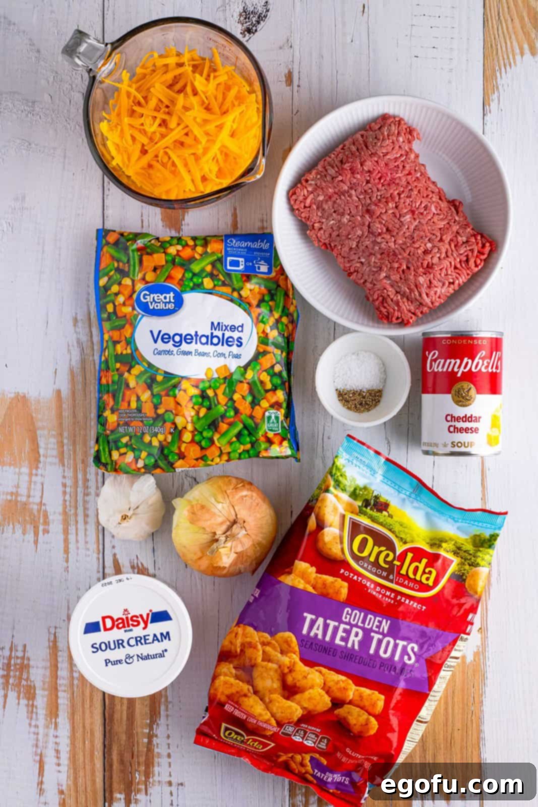 Lean ground beef, onion, kosher salt, black pepper, garlic, frozen mixed vegetables, condensed cheddar soup, sour cream, shredded sharp cheddar cheese and
a bag frozen tater tots.