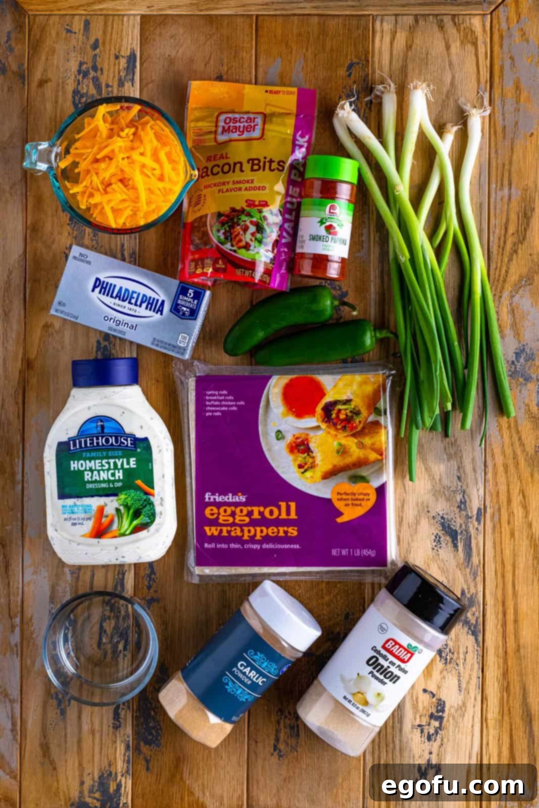 Spicy Creamy Egg Roll Poppers 5 All the fresh ingredients laid out: Cream cheese, shredded sharp cheddar cheese, fresh jalapeños, bacon pieces, green onion, garlic powder, onion powder, smoked paprika, egg roll wrappers, water, and oil.
