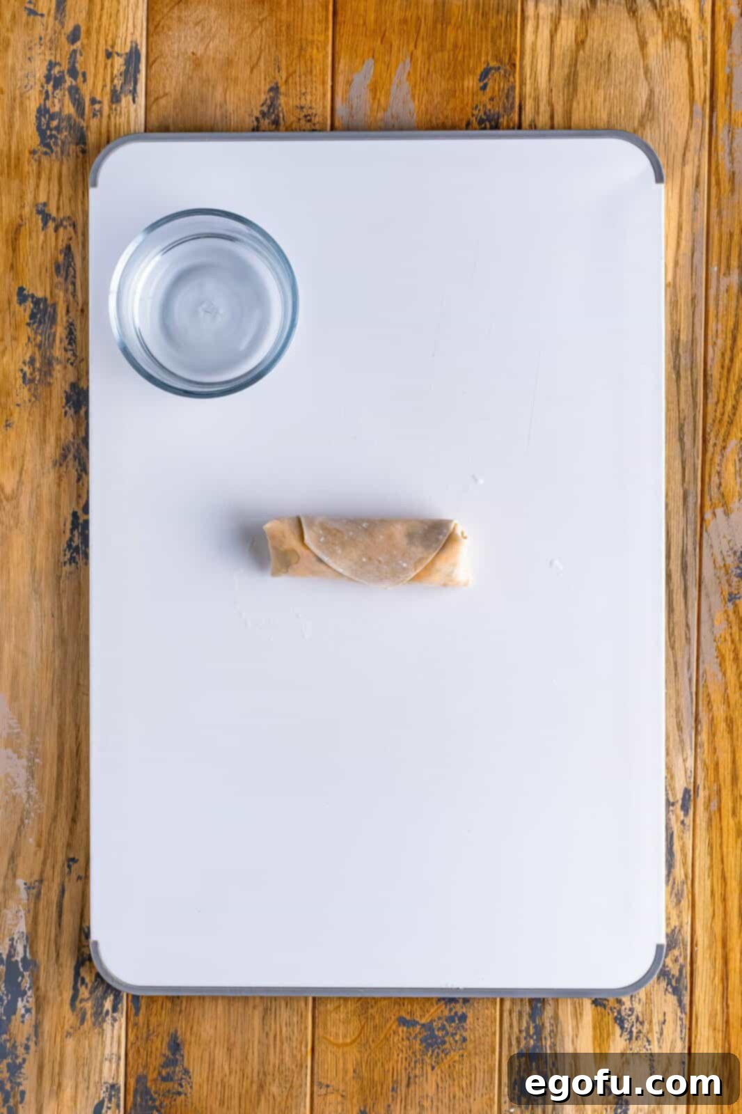 Spicy Creamy Egg Roll Poppers 10 A perfectly rolled egg roll with jalapeño popper filling, sealed and ready for frying.