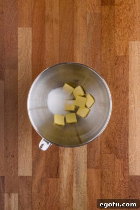 Butter Bathed Cloud Rolls 19 Bowl of a stand mixer butter slices and sugar.