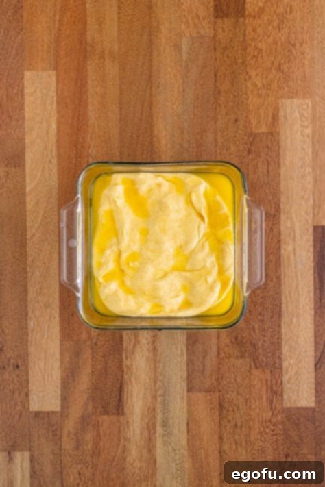 Butter Bathed Cloud Rolls 25 A glass dish with bread dough and melted butter.