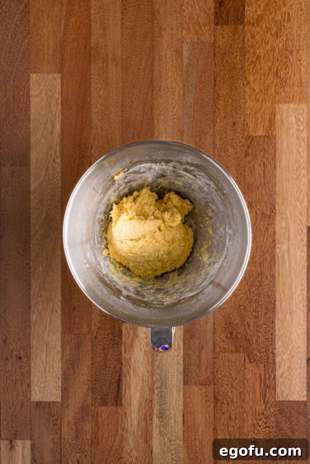 Butter Bathed Cloud Rolls 8 A stand mixer bowl showing the early stages of sticky bread dough forming, clinging to the sides of the bowl.