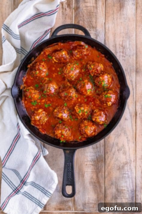 Looking down on Porcupine Meatballs with sauce in a cast iron skillet.