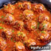 A closeup of a skillet of homemade porcupine meatballs in sauce.