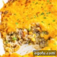 Golden Cheesy Beef and Rice Bake 12 Close up of a homemade cheesy ground beef and rice casserole with a serving missing.