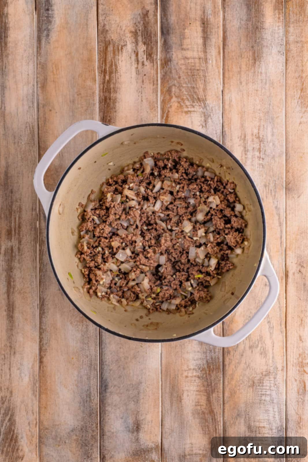 Golden Cheesy Beef and Rice Bake 5 A dutch oven with perfectly browned ground beef, softened diced onion, and minced garlic.