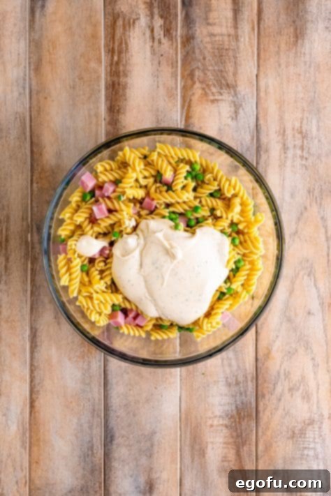 Ruby Tuesday Inspired Creamy Pasta Salad 14 A bowl of rotini pasta, ham, peas, and mayo based dressing.