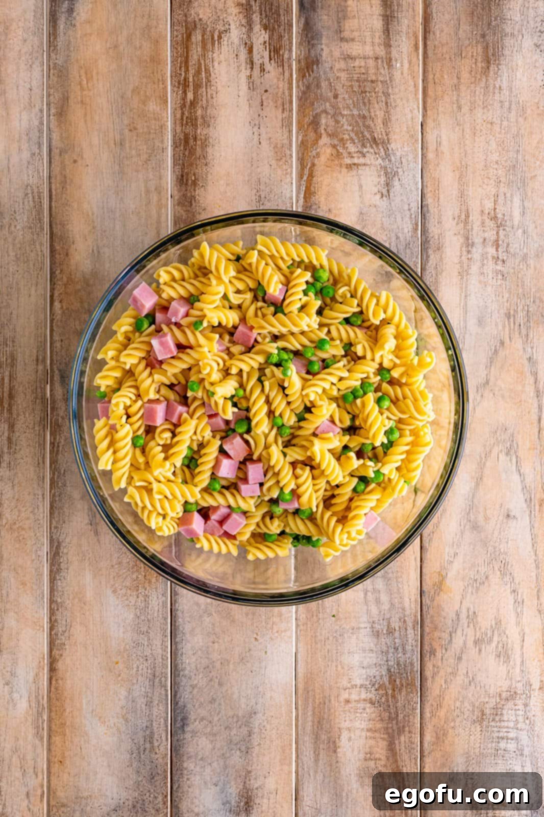 Ruby Tuesday Inspired Creamy Pasta Salad 7 A bowl of rotini, ham, and peas.