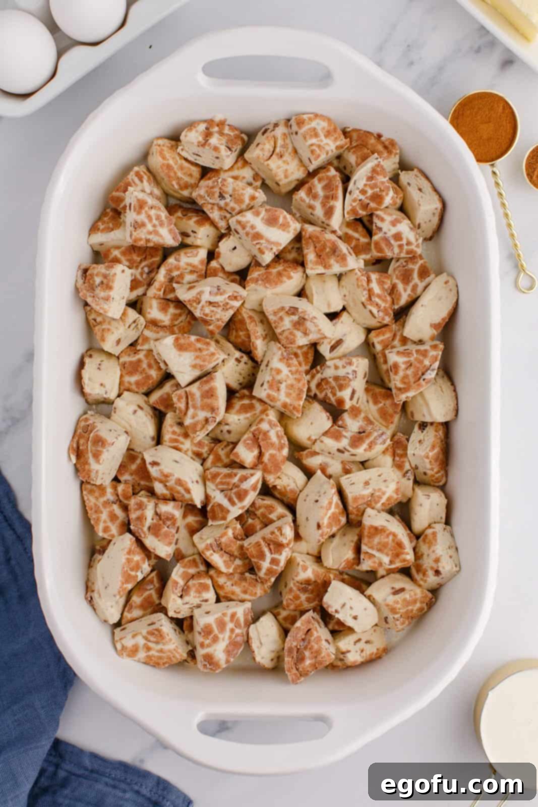 Pull-Apart Cinnamon Delight 5 A baking dish with cut up cinnamon buns arranged, ready for the custard mixture.