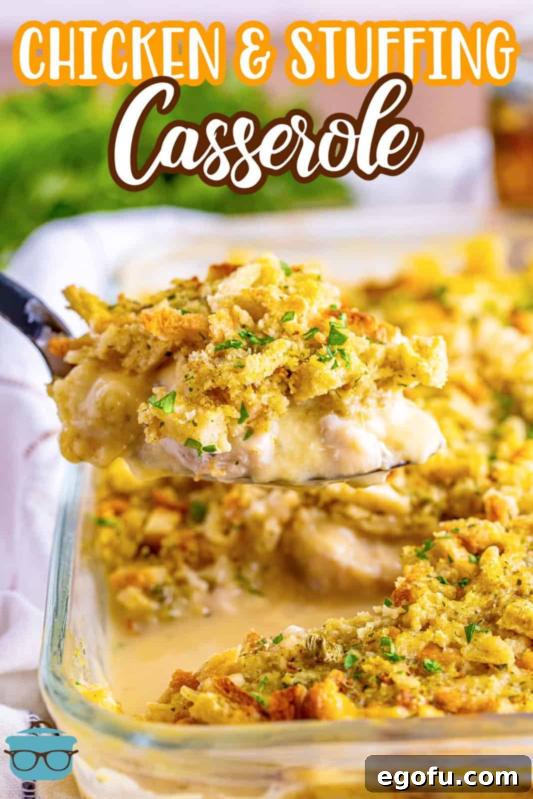A glass dish with Chicken and Stuffing Casserole and a serving spoon with some in the foreground.