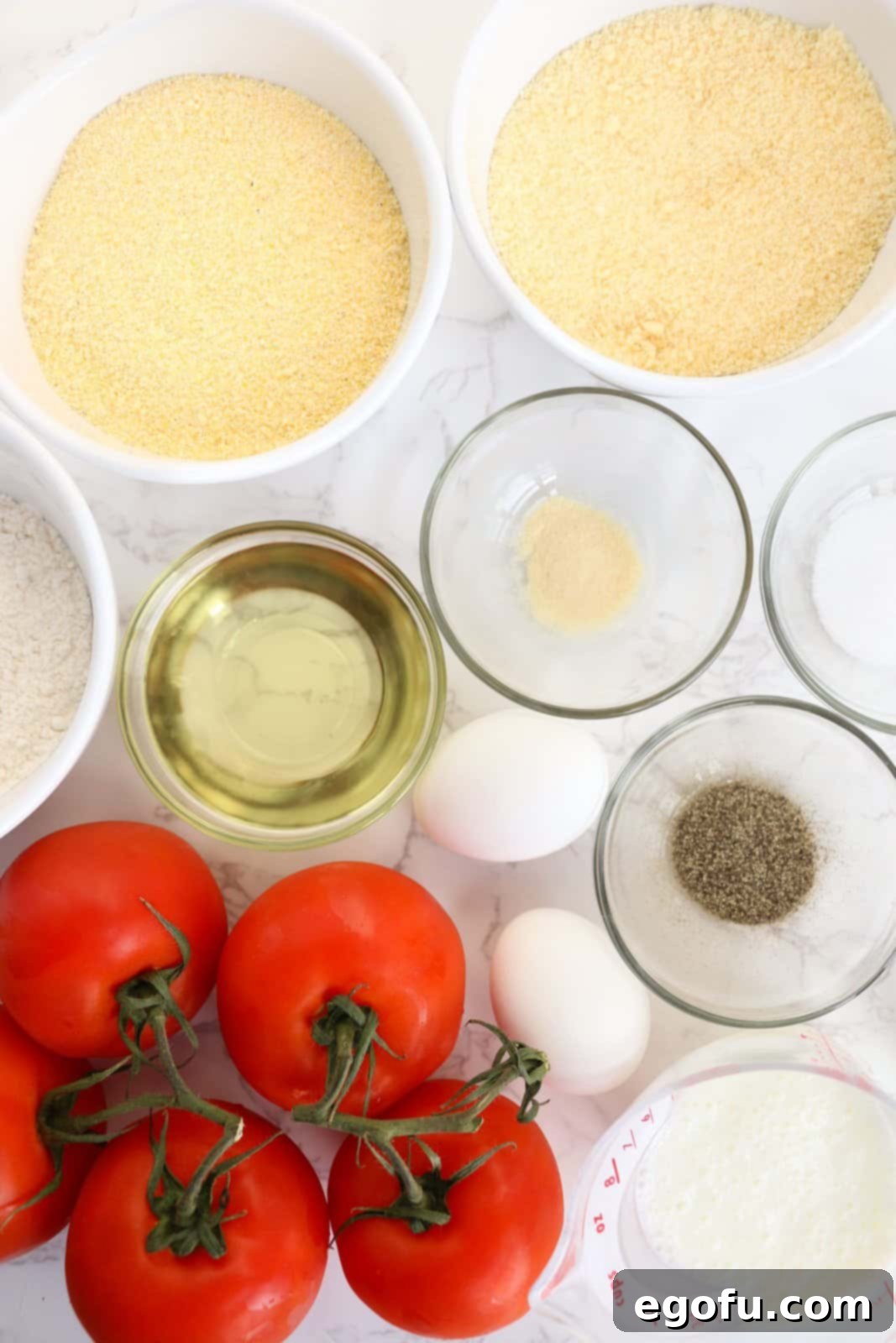 Beefsteak tomatoes, garlic powder, buttermilk, large eggs, cornmeal, all purpose flour, Grated Parmesan cheese, salt, pepper, vegetable oil, and minced fresh basil.